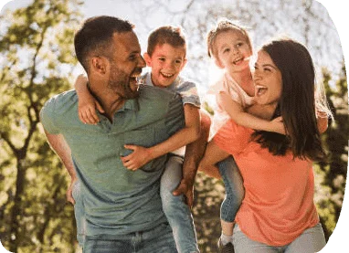couple smiling with their children on their backs