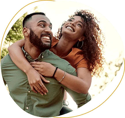 couple smiling with the woman on the back of the man